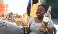 Una mujer garífuna muestra un aceite de coco y una bebida llamada Gifitti, productos de consumo popular en Lívingston, Izabal. (Foto Prensa Libre: Dony Stewart)