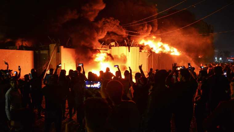Varias personas graban con sus teléfonos móviles el incendio. Foto Prensa Libre: AFP.