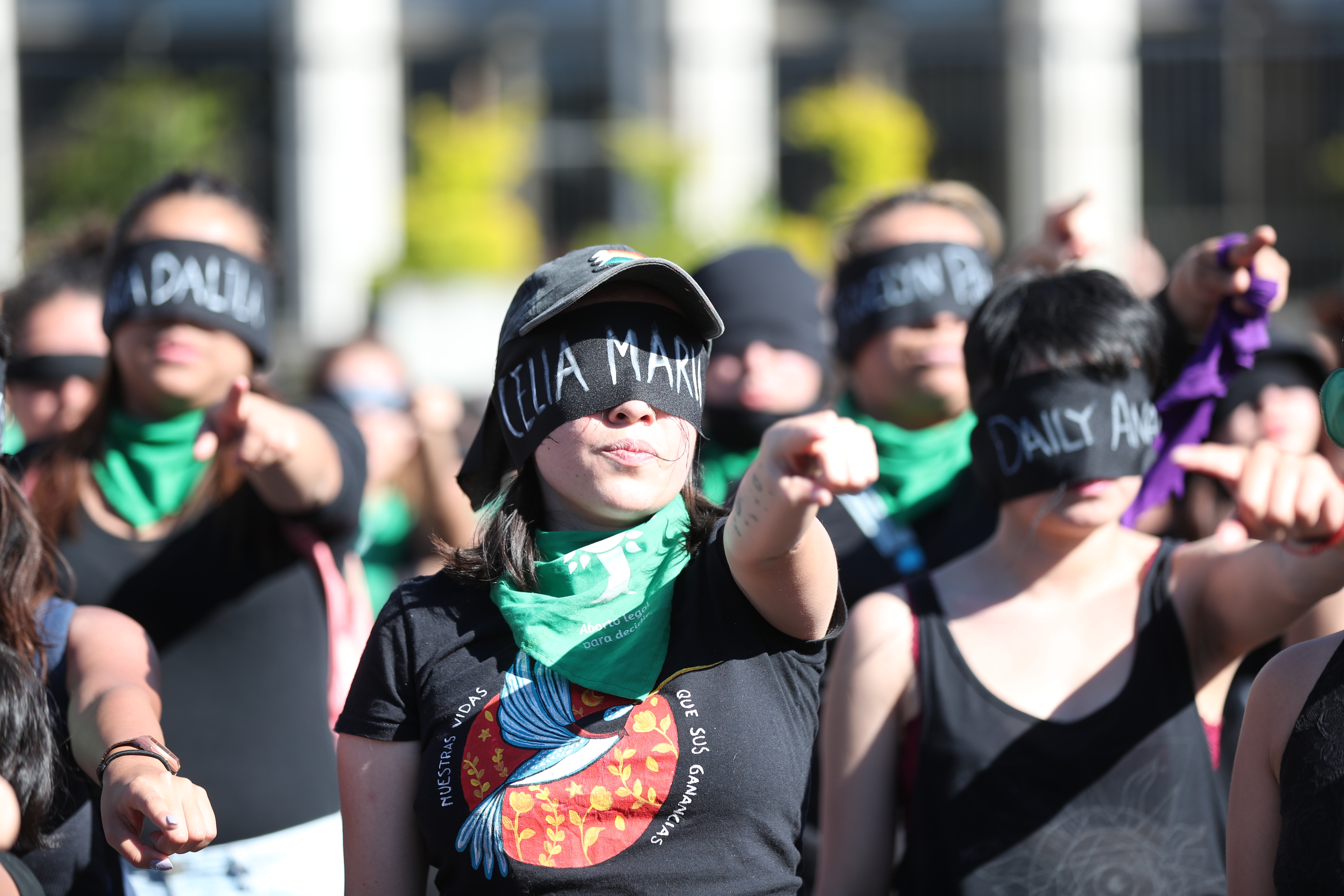 Con los ojos vendados y vestidas de negro, varias mujeres reunidas frente a la Corte Suprema de Justicia cantan comparsas en conmemoracin de la tragedia en el Hogar Seguro.