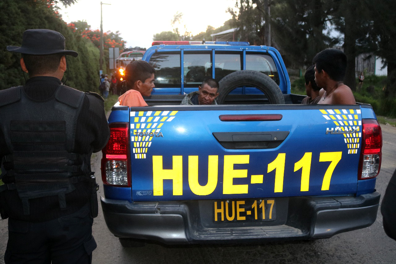 Cuatro hombres esperan su traslado en la parte trasera de una autopatrulla de la Policía Nacional Civil en el km 254 de la Ruta Interamericana, tras ser señalados de intentar asaltar un bus. (Foto Prensa Libre: Mike Castillo)
