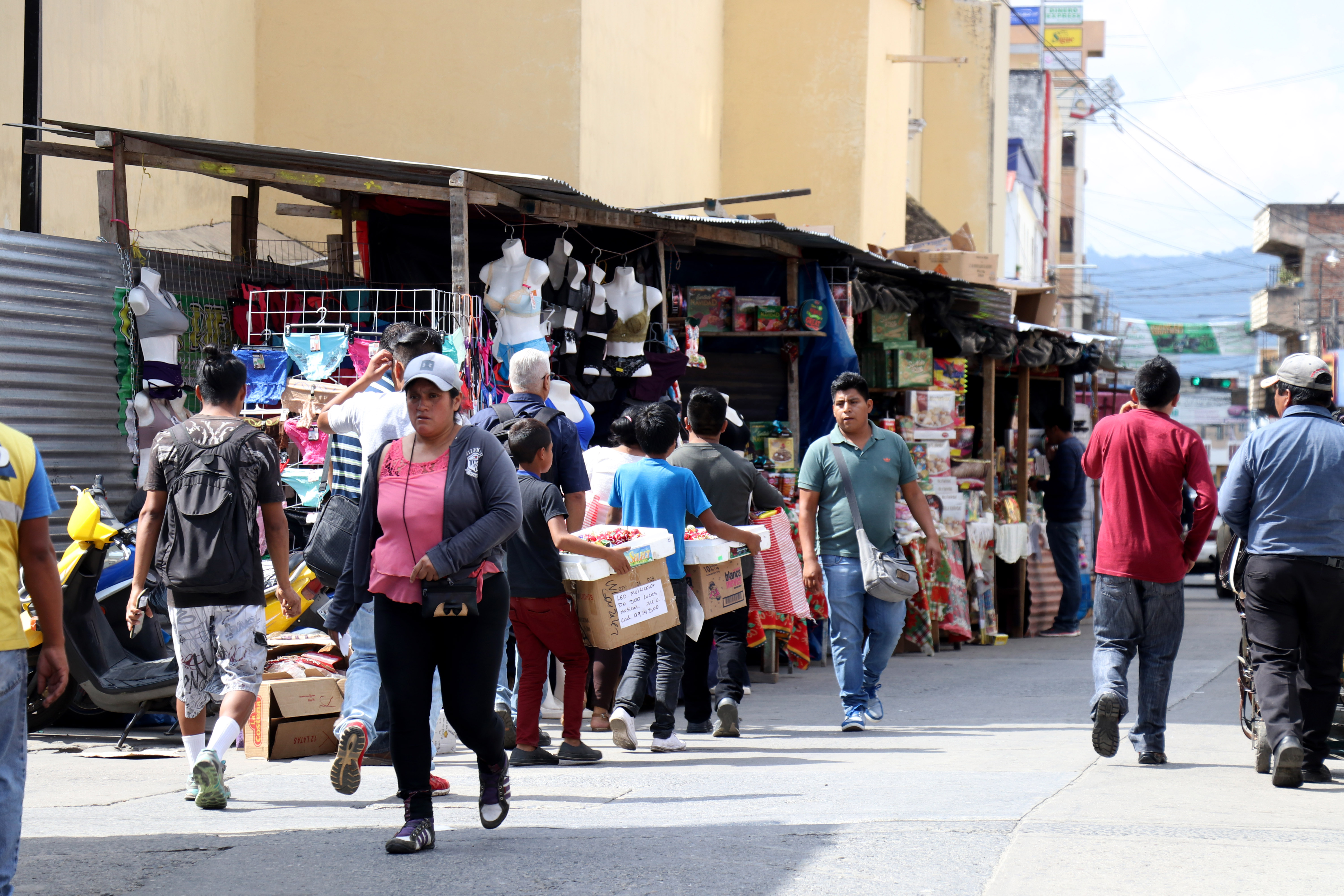 Peatones caminan a la mitad de la calle a un costado de la catedral de Huehuetenango porque las ventas navideñas ocupan las aceras. (Foto Prensa LIbre: Mike Castillo)