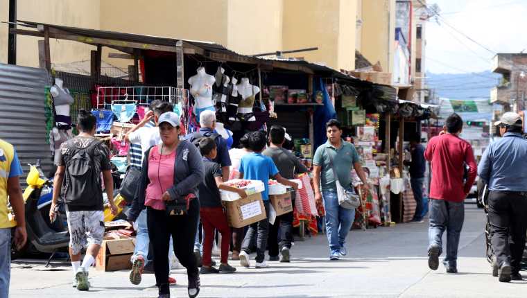Peatones caminan a la mitad de la calle a un costado de la catedral de Huehuetenango porque las ventas navideñas ocupan las aceras. (Foto Prensa LIbre: Mike Castillo)