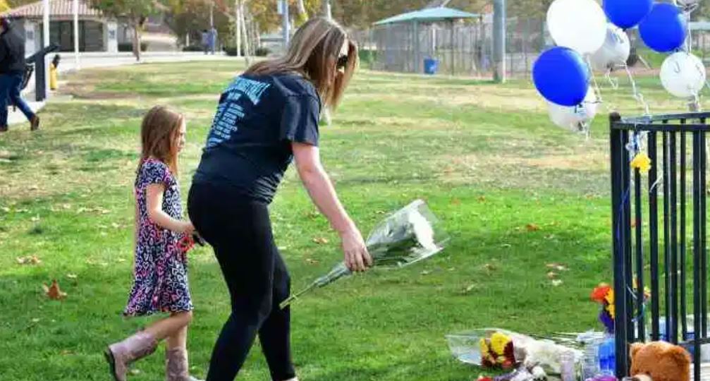 Personas colocan flores en el área donde hubo un tiroteo en una escuela de California el 15 de noviembre 2019. (Foto Prensa Libre: AFP).