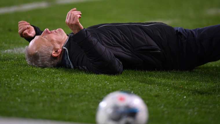 El entrenador Christian Streich luego de ser golpeado por David Abraham. (Foto Prensa Libre: AFP).