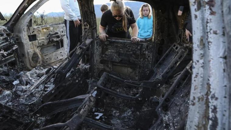 Members of the Lebaron family watch the burned car where part of the nine murdered members of the family were killed and burned during an gunmen ambush on Bavispe, Sonora mountains, Mexico, on November 5, 2019. - US President Donald Trump offered Tuesday to help Mexico "wage war" on its cartels after three women and six children from an American Mormon community were murdered in an area notorious for drug traffickers. (Photo by Herika MARTINEZ / AFP) / The erroneous mention[s] appearing in the metadata of this photo by Herika MARTINEZ has been modified in AFP systems in the following manner: [AFP PHOTO / Herika MARTINEZ ] instead of [AFP PHOTO / STR ]. Please immediately remove the erroneous mention[s] from all your online services and delete it (them) from your servers. If you have been authorized by AFP to distribute it (them) to third parties, please ensure that the same actions are carried out by them. Failure to promptly comply with these instructions will entail liability on your part for any continued or post notification usage. Therefore we thank you very much for all your attention and prompt action. We are sorry for the inconvenience this notification may cause and remain at your disposal for any further information you may require.