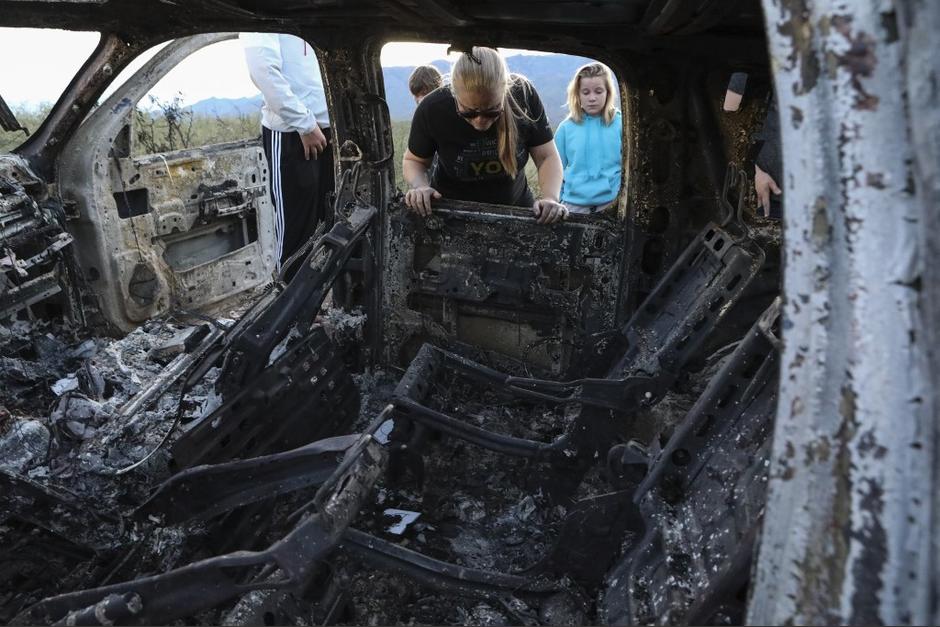 Familiares de los masacrados en México observan el estado en que quedaron los vehículos. (Foto: AFP)