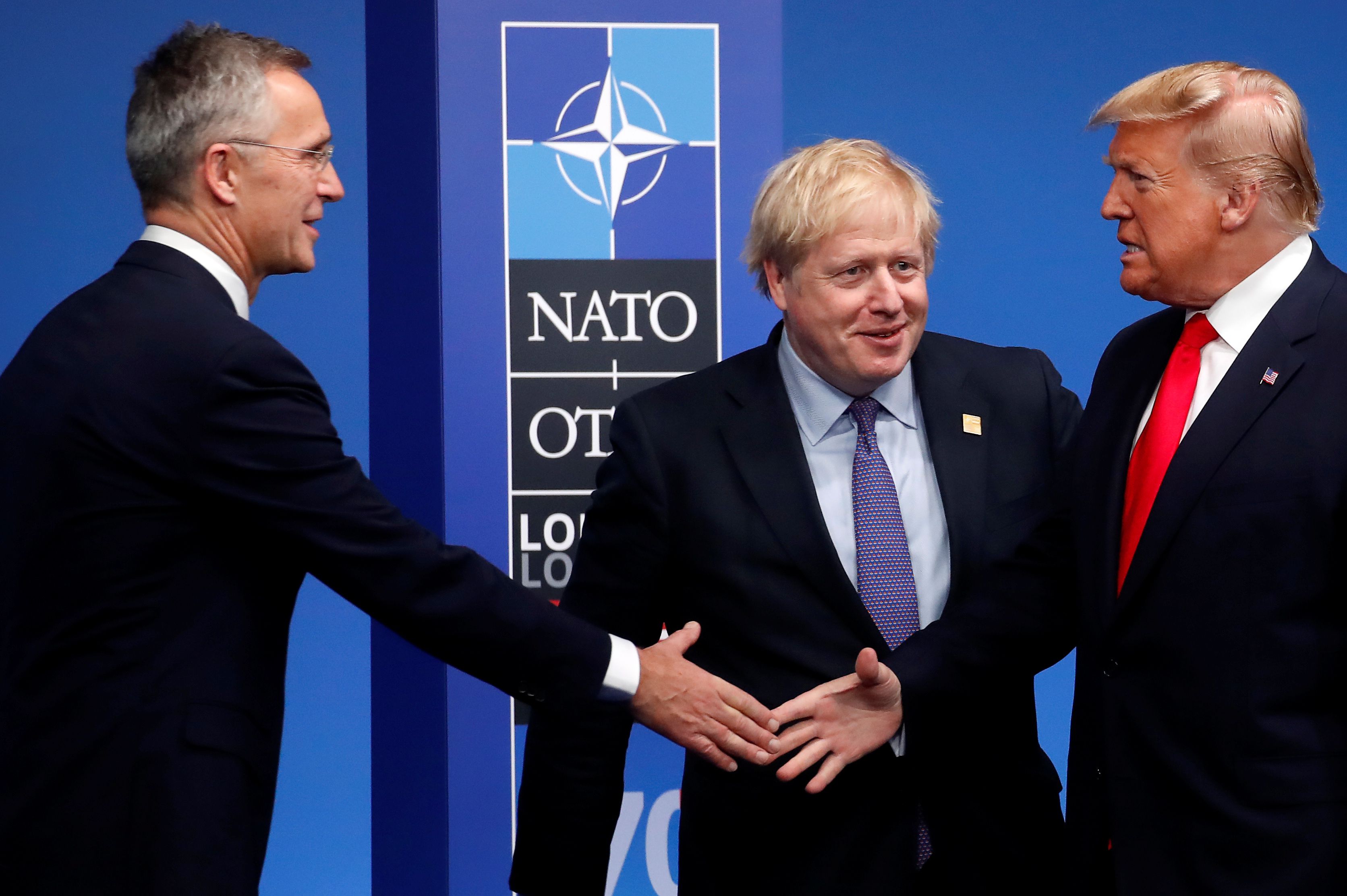 El presidente de los Estados Unidos Donald Trump se saluda con el secretario general de la OTAN Jens Stoltenberg, en medio el primer ministro británico Boris Johnson. (Foto Prensa Libre: AFP)