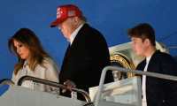 (FILES) In this file photo taken on December 1, 2019, US President Donald Trump, First Lady Melania Trump and son Barron step off Air Force One upon arrival at Andrews Air Force Base, Maryland. - Melania Trump on December 4, 2019, publicly rebuked Constitutional law professor Pamela Karlan,who used her 13-year-old son's name to make a point during an impeachment hearing against the president. Karlan invoked Barron Trump to demonstrate how the Constitution imposes distinctions between a monarch's power and that of a president. "The constitution says there can be no titles of nobility," Karlan told lawmakers, "So while the president can name his son 'Barron', he can't make him a baron." The pun led to chuckles in the congressional hearing room, but Melania Trump made clear it was no laughing matter. (Photo by MANDEL NGAN / AFP)