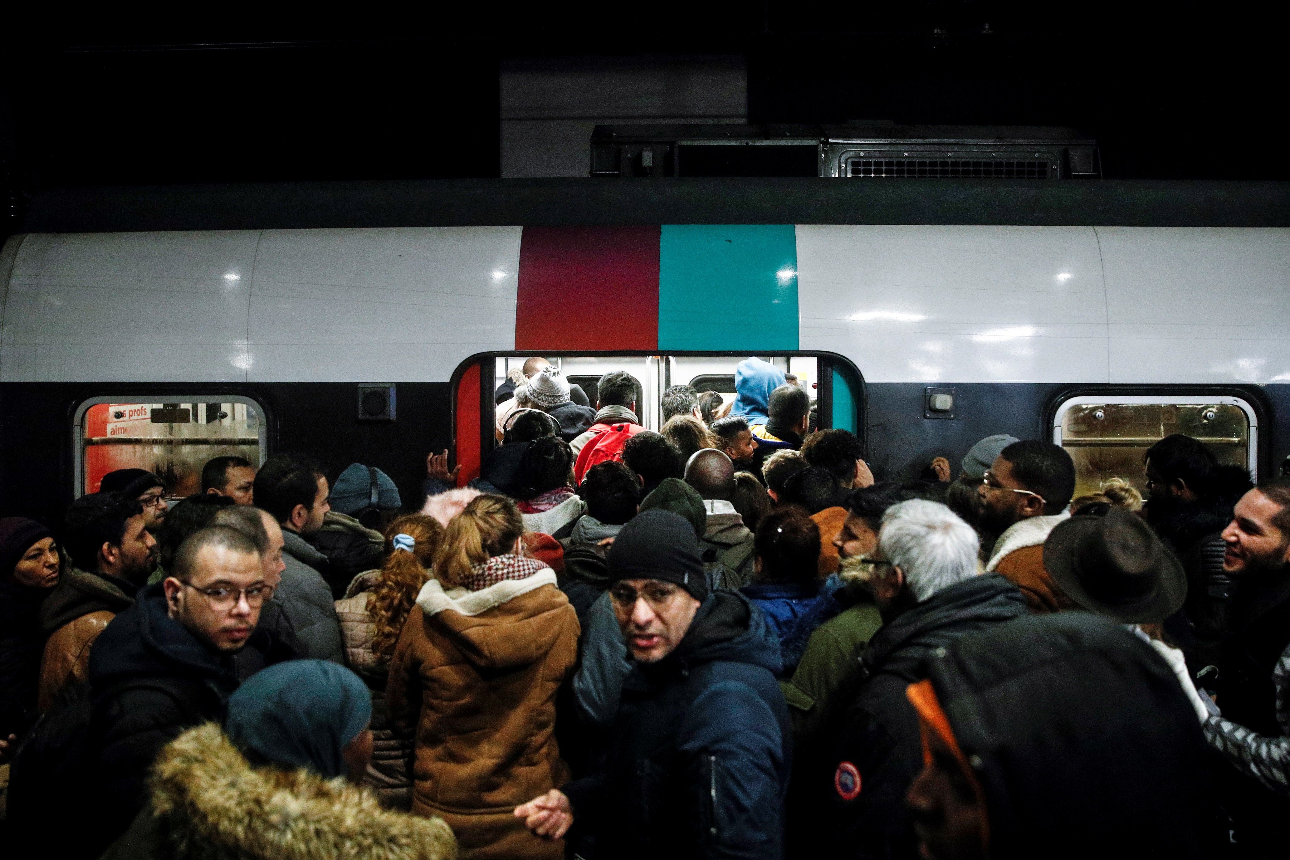Paris (France), 09/12/2019.- Commuters try to enter a packed train (RER) during a general strike action at Gare Du Nord train station in Paris,, France, 09 December 2019. Unions representing railway and transport workers and many others in the public sector have called for a general strike and demonstration to protest against French government's reform of the pension system. (Protestas, Francia) EFE/EPA/YOAN VALAT