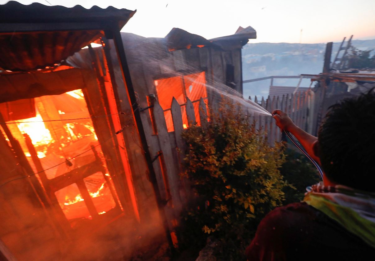 Vista de una de las viviendas que han quedado consumidas por las llamas en un incendio forestal que alcanzó un sector poblado de la ciudad costera de Valparaíso. (Foto Prensa Libre: EFE). 