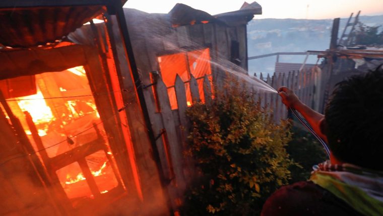 Vista de una de las viviendas que han quedado consumidas por las llamas en un incendio forestal que alcanzó un sector poblado de la ciudad costera de Valparaíso. (Foto Prensa Libre: EFE). 