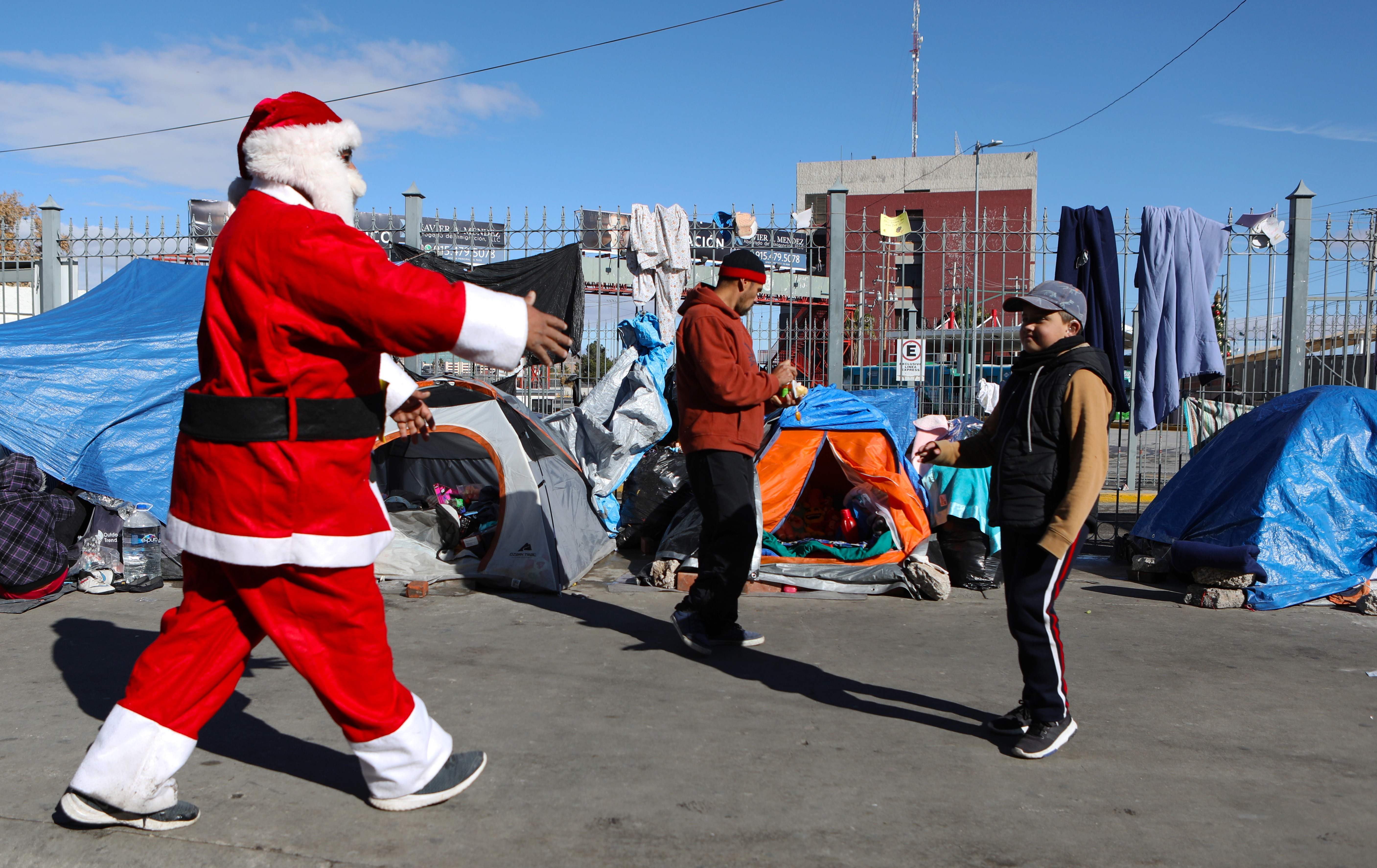 Santa saluda a un niño migrante en Ciudad Juárez. (Foto Prensa Libre: AFP)