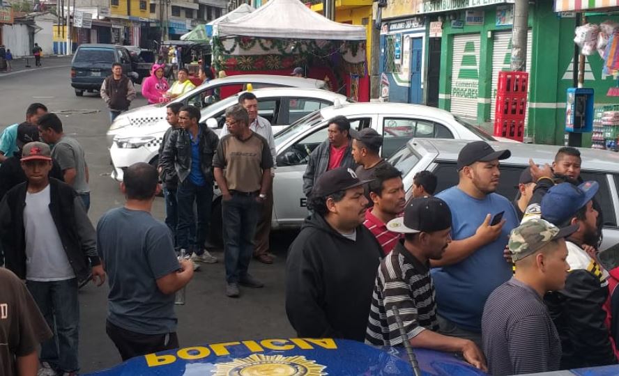 Curiosos se reúnen en la estación de la PNC de la colonia El Milagro, a donde fue trasladado el presunto extorsionista captura. (Foto Prensa Libre: Comuna de Mixco). 