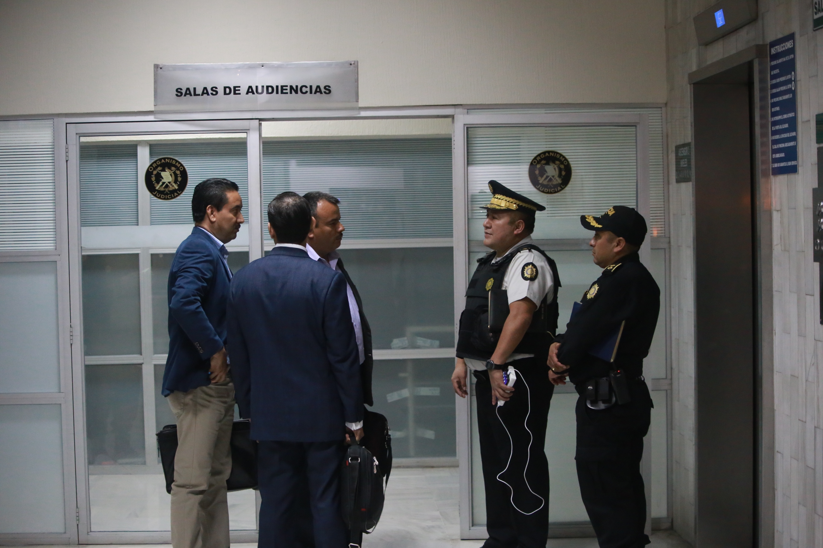 El director de la PNC Roberto Tohom Escobar dialoga con asesores legales para asistir al policía detenido quien comparecerá ante un juez. (Foto Prensa Libre: Cortesía PNC) 