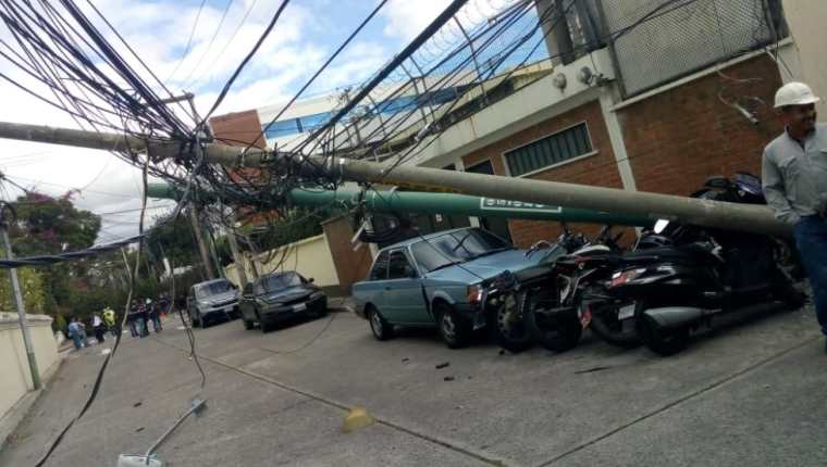 Caída de árbol provocó que dos postes fueran derribados en la zona 10 de la capital. (Foto Prensa Libre: Conred). 