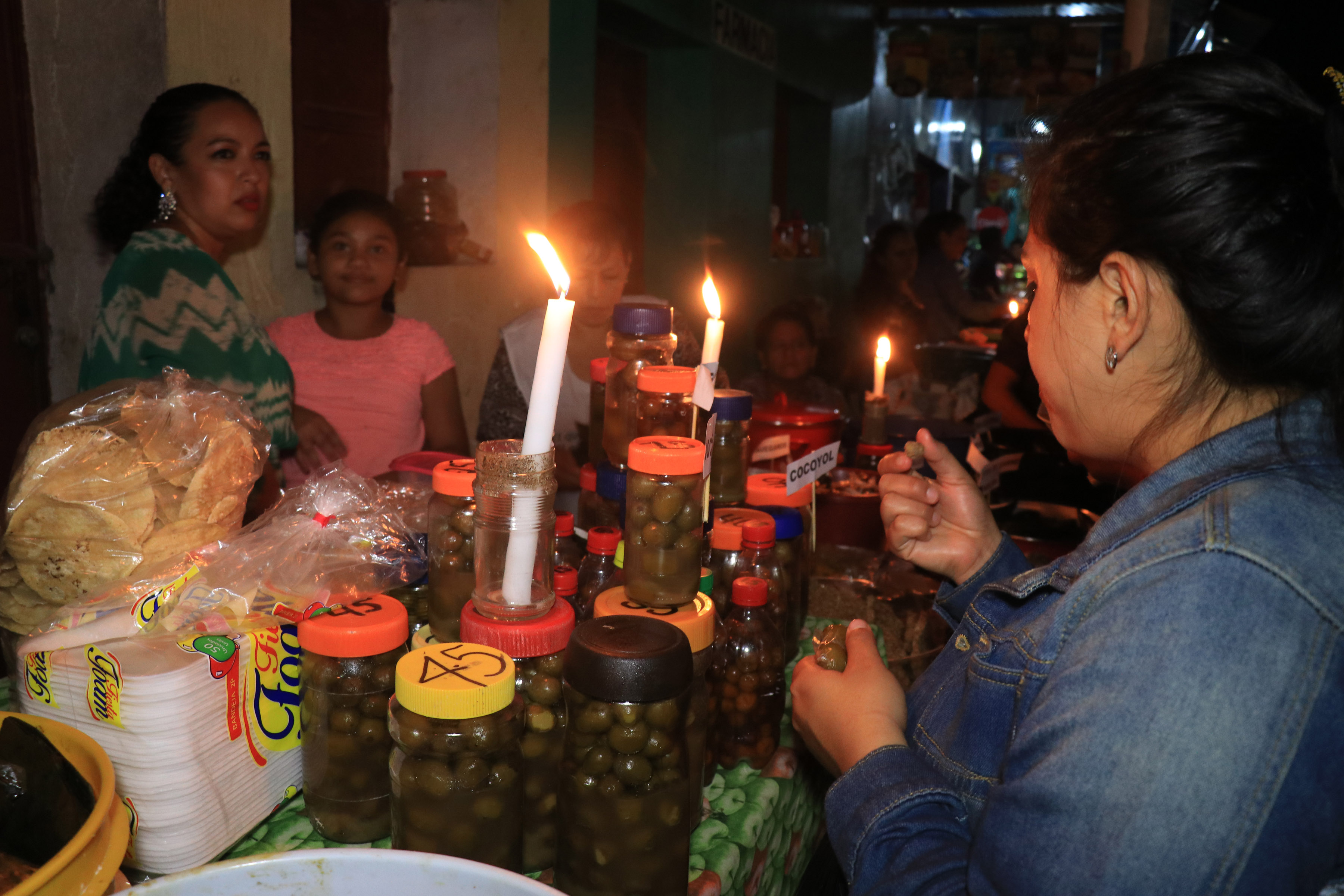 Una mujer preuba uno de los dulces que frecen familias de San Francisco en las tradicionales mesitas, las cuales marcan el inicio de la temporada navideña en Petén. (Foto Prensa Libre: Dony Stewart)