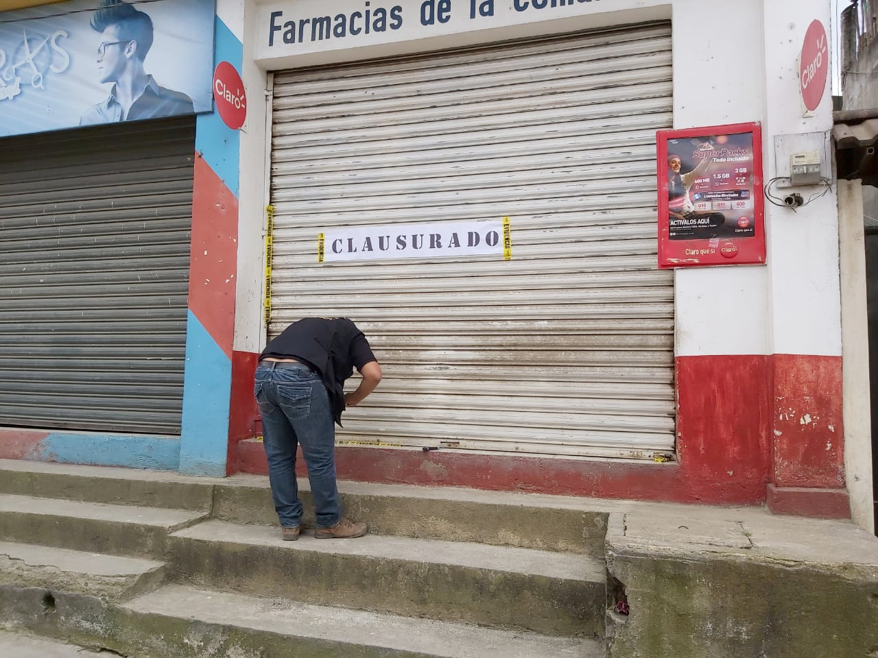 Un agente de la Fiscalía de Delitos Contra la Propiedad Intelectual clausura una farmacia en Jacaltenango Huehuetenago. (Foto Prensa Libre: Cortesía PNC)
