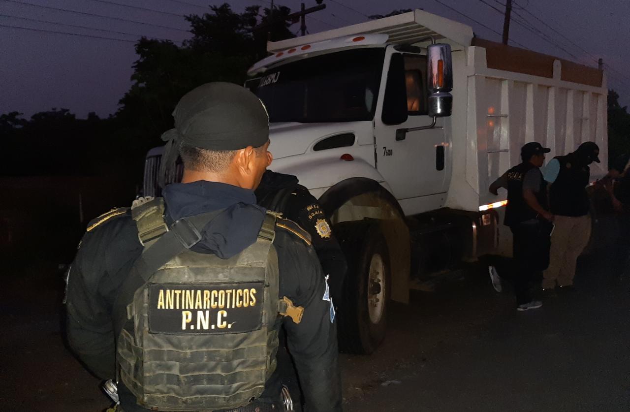 Un agente antinarcóticos custodia el camión donde era transportada la droga. (Foto Prensa Libre: PNC) 