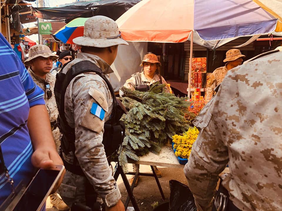 Agentes de la PNC resguardan las ramillas de pinabete decomisadas en el mercado San Nicolás en Retalhuleu. (Foto Prensa Libre: Rolando Miranda) 