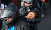Un niño duerme en los brazos de su madre a bordo de una motocicleta; ignora que su vida corre peligro. (Foto Prensa Libre: Esbin García) 