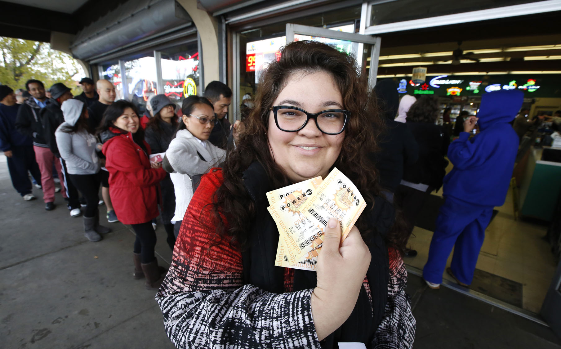 Laura Woodward displays the Powerball lottery tickets she bought for her office pool at Lichine's Liquor store, Wednesday, Jan. 13, 2016, in Sacramento, Calif. The Powerball jackpot for Wednesday night's drawing to be over $1 billion, the largest lottery jackpot in the world.(AP Photo/Rich Pedroncelli) ORG XMIT: CARP106