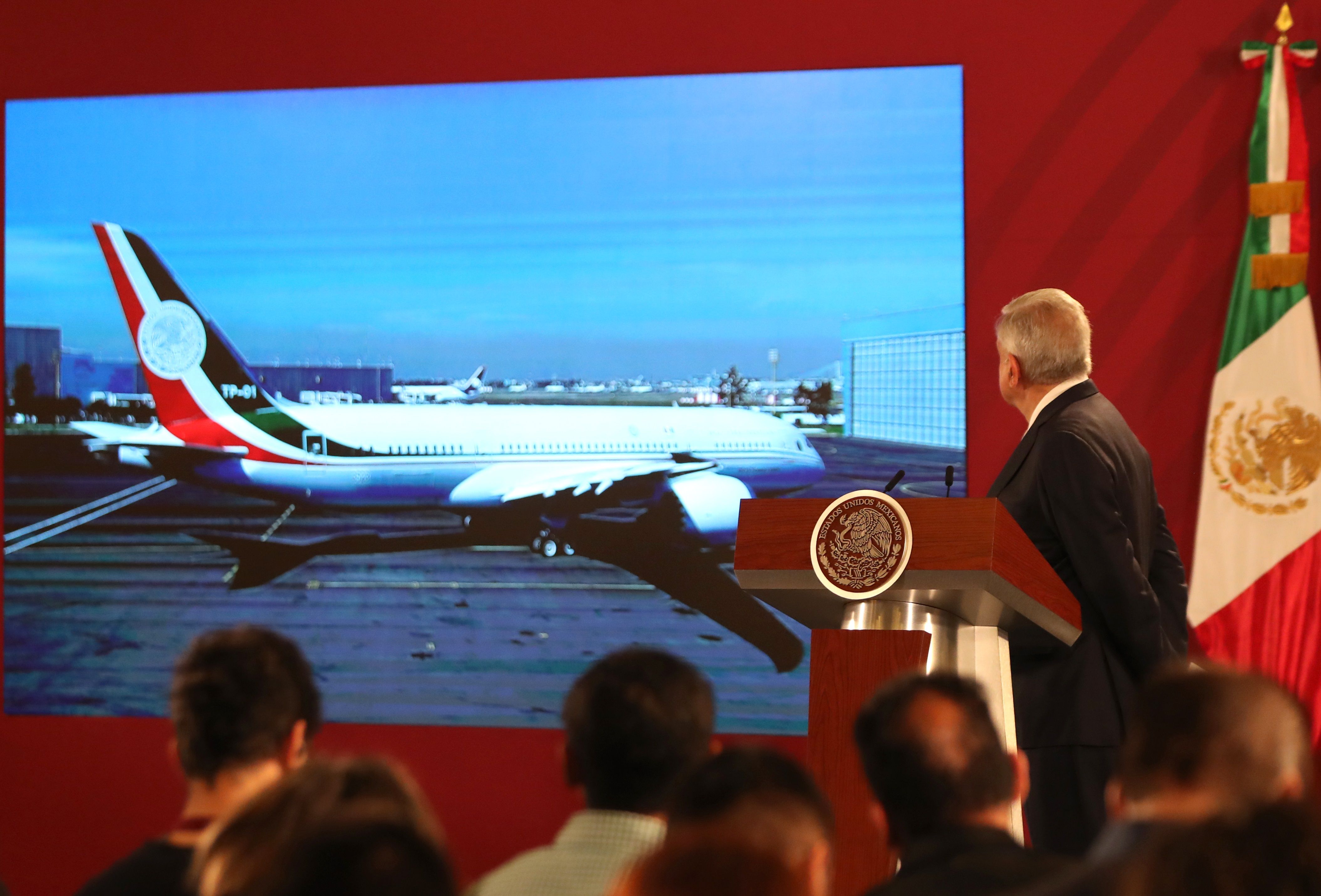 El presidente de México, Andrés Manuel López Obrador, observa en una pantalla el avión presidencial que se envió a EE.UU. para su venta. (Foto Prensa Libre: EFE)