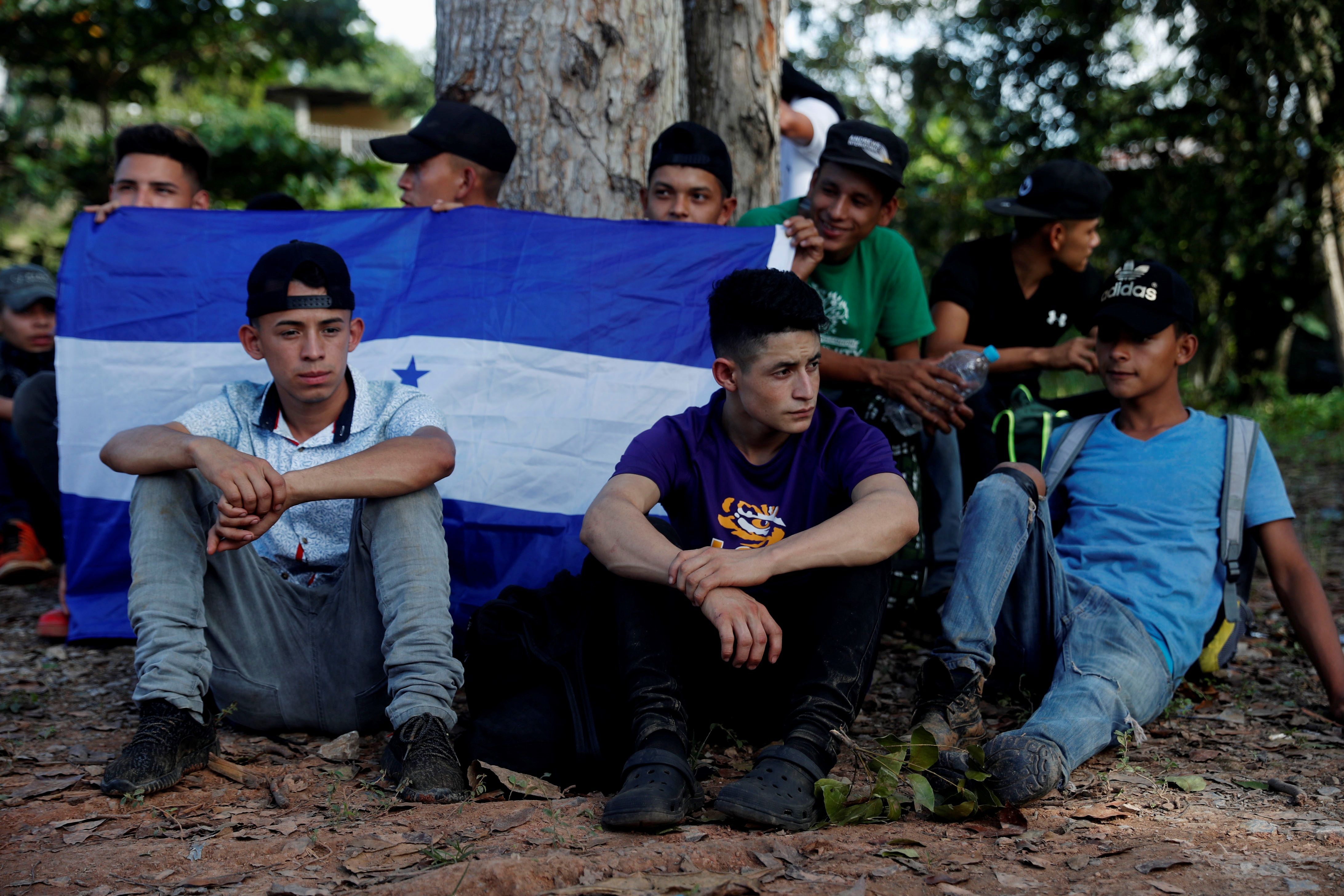 Migrantes hondureños esperan en Morales, Izabal luego de que la Policía Nacional Civil los bajara de los autobuses en los que se movían en caravana rumbo a Estados Unidos. (Foto Prensa Libre: EFE)