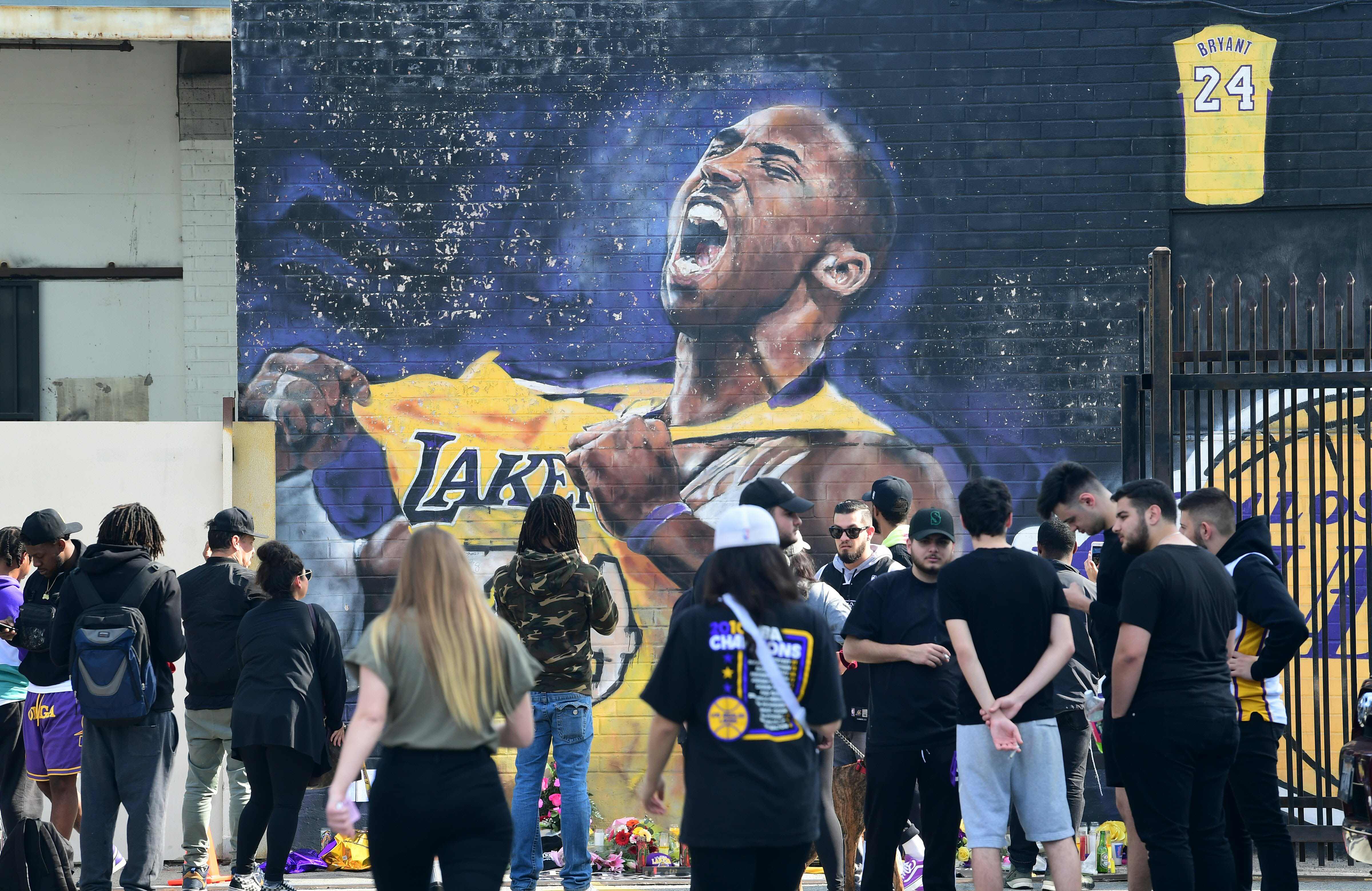 Fanáticos se reúnen para llorar la muerte de la leyenda de la NBA Kobe Bryant en un mural cerca del Staples Center en Los Ángeles, California, un día después del trágico accidente. (Foto Prensa Libre: AFP).