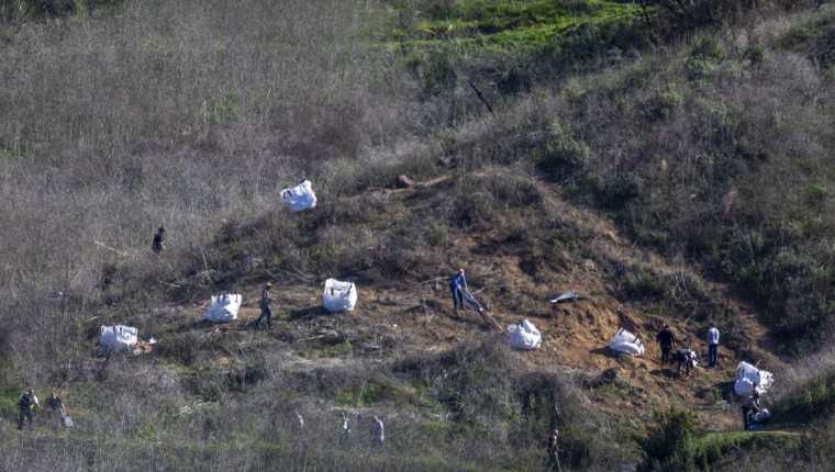 Los investigadores trabajan en la escena del accidente del helicóptero, donde murió la exestrella de la NBA, Kobe Bryant, y su hija de 13 años. (Foto Prensa Libre: AFP). 