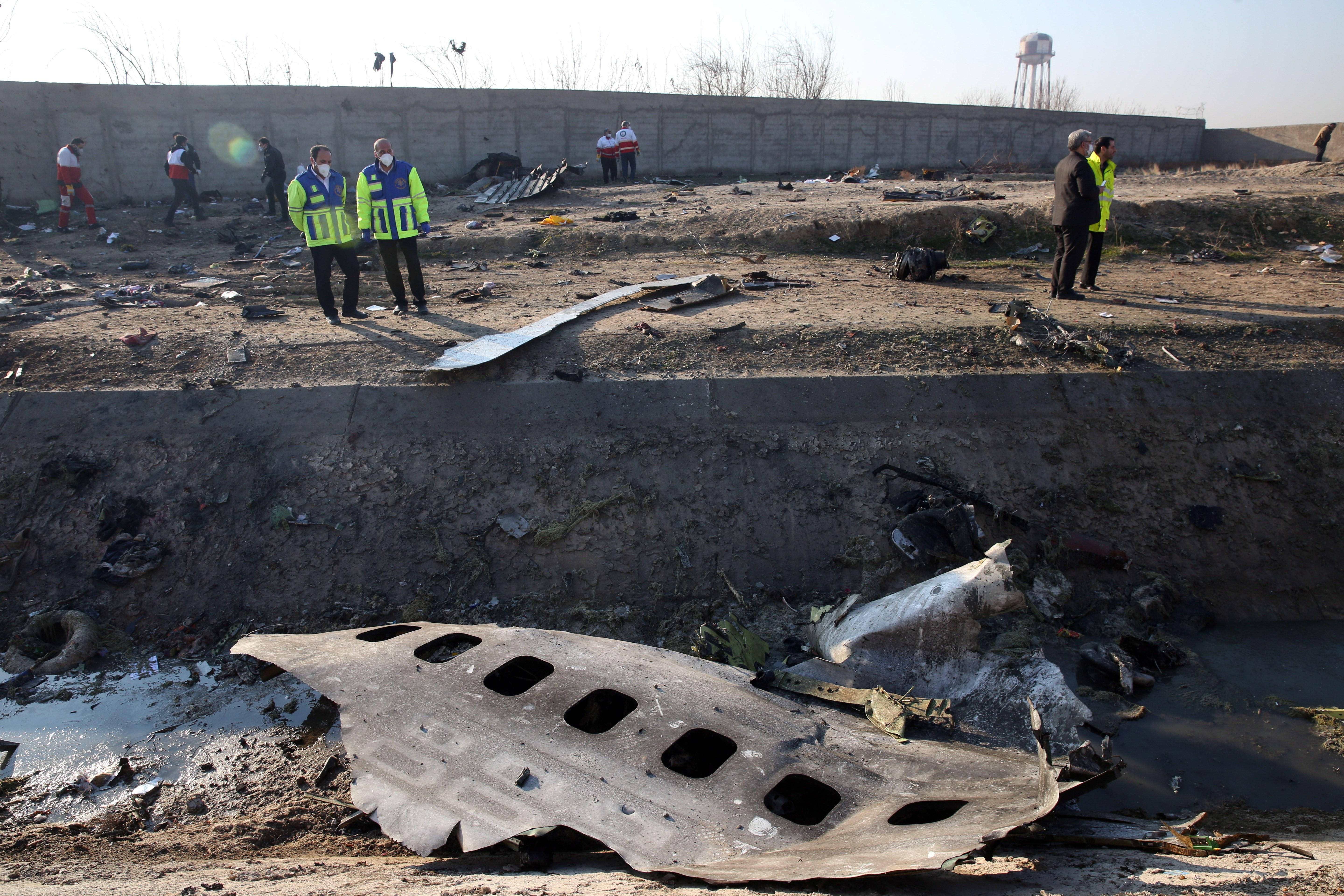 -FOTODELDIA- ABD01. SHAHRIAR (IRÁN), 08/01/2020.- Miembros de los servicios de emergencia observan parte del fuselahe del Boeing 737 de la compañía ucraniana UIA que se ha estrellado esta madrugada en Teherán (Israel). Nacionales de siete países, entre ellos 63 canadienses, han muerto en el accidente aéreo. EFE/ Abedin Taherkenareh