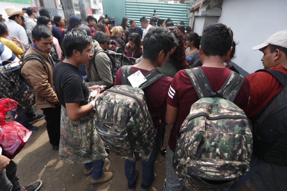 Deportados, en las afueras de la Fuerza Aérea, avenida Hincapié, zona 13, tratan de ponerse de acuerdo para retirarse del lugar. (Foto Prensa Libre: Esbin García)