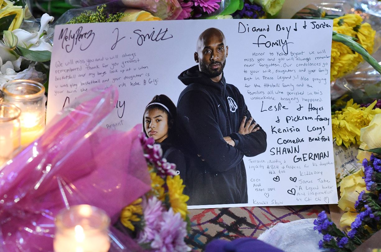 Se ve una nota entre flores y velas en un monumento improvisado mientras los fanáticos lloran la muerte de la leyenda de la NBA Kobe Bryant, quien murió junto con su hija y otras siete personas en un accidente de helicóptero. (Foto Prensa Libre: AFP)