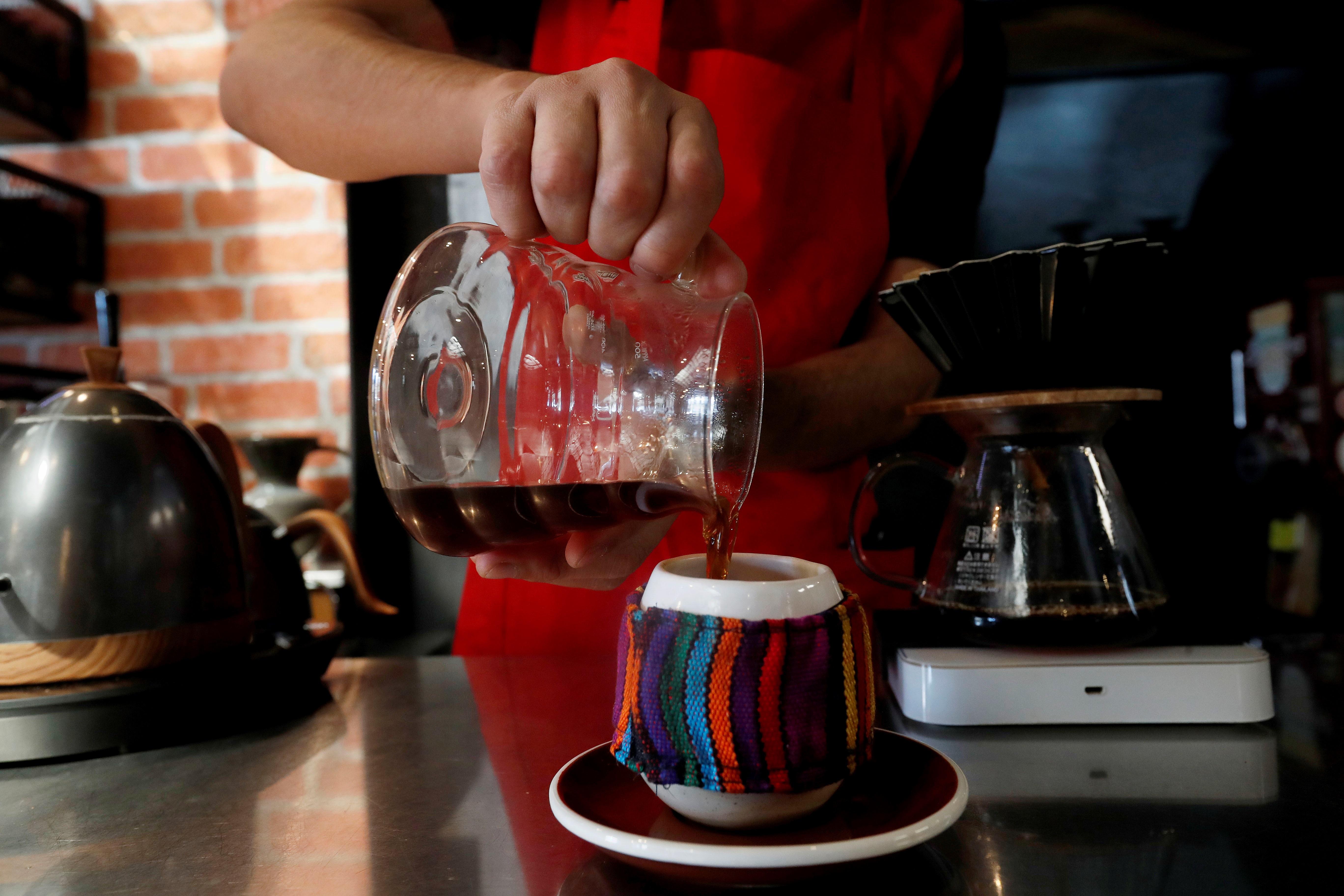 Juan Luna, barista del la tienda de café El Injerto, sirve un café de método V60 el pasado 13 de enero, en Ciudad de Guatemala (Guatemala). (Foto Prensa Libre: EFE)