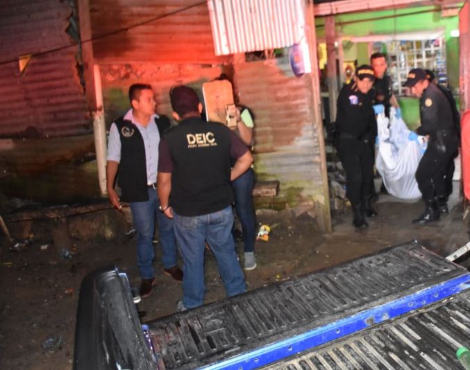 Agentes de la PNC retiran de la vivienda el cadáver de Carlos Humberto Santos Ramos, quien murió baleado en Izabal. (Foto Prensa Libre: Dony Stewart).  