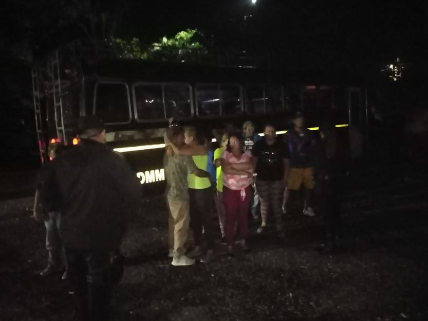 Migrantes hondureños junto a unos de los buses que los trajo desde la frontera con México. (Foto Prensa Libre: Conred).