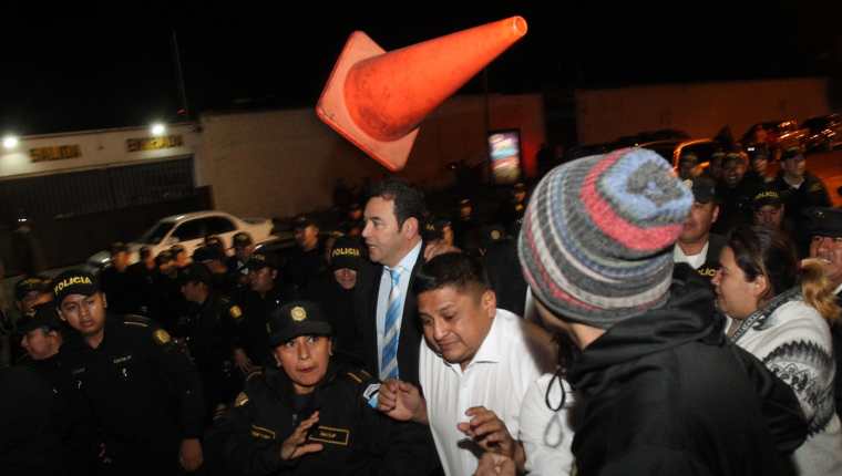Momento en que, en medio de una protesta ciudadana, Jimmy Morales intenta sin éxito ingresar a un hotel para ser juramentado como diputado al Parlacén. (Foto Prensa Libre: EFE)