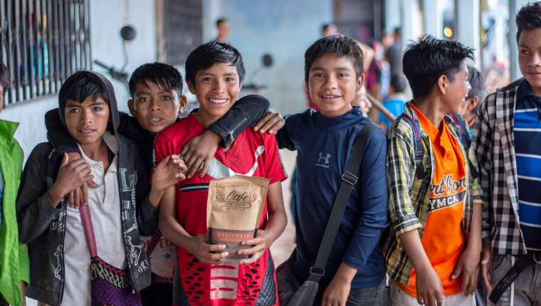 Un grupo de niños de Guaisná, San Mateo Ixtatán, sostienen una de las bolsas de café cuyas ganancias pagan el salario de los maestros que este año imparten clases en el básico. (Foto Prensa Libre: Mike Castillo)