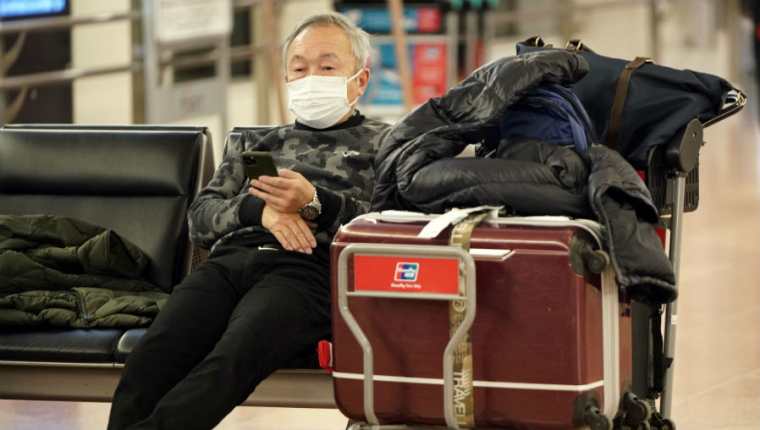 Los viajeros deben protegerse con boquilla para evitar contagio. (Foto Prensa Libre: EFE)
