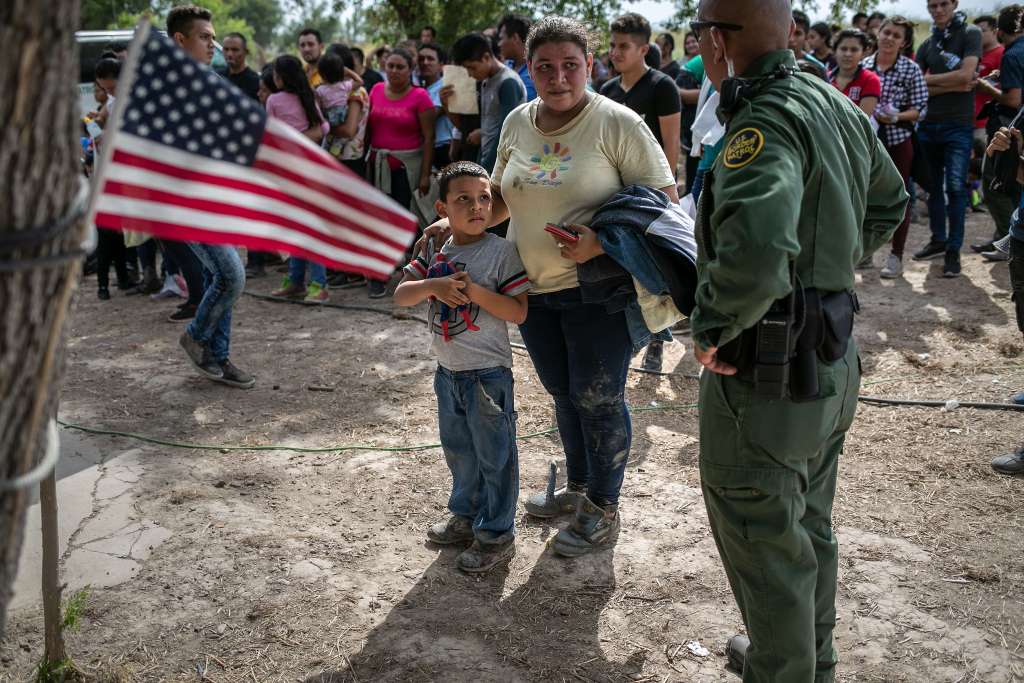 Agentes de la Patrulla Fronteriza de los EE.UU., entablan diálogo con los migrantes luego de tomarlos en custodia