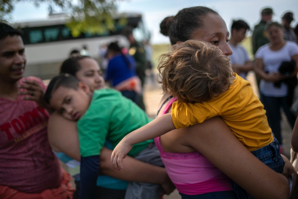 Migrantes salvadoreña sostiene a su hijo de 2 años, antes de ser trasladados a las instalaciones de la Patrulla Fronteriza