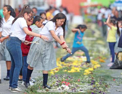 Alumnas del colegio El Rosario realizaron una alfombra con flores para el paso de la procesión. Foto Prensa Libre: Óscar Rivas