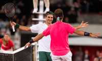 El suizo Roger Federer (de blanco) busca abrazar al español Rafael Nadal después de vencerlo en el evento caritativo de Africa Cape Town en febrero de 2020.  (Foto Prensa Libre: EFE)