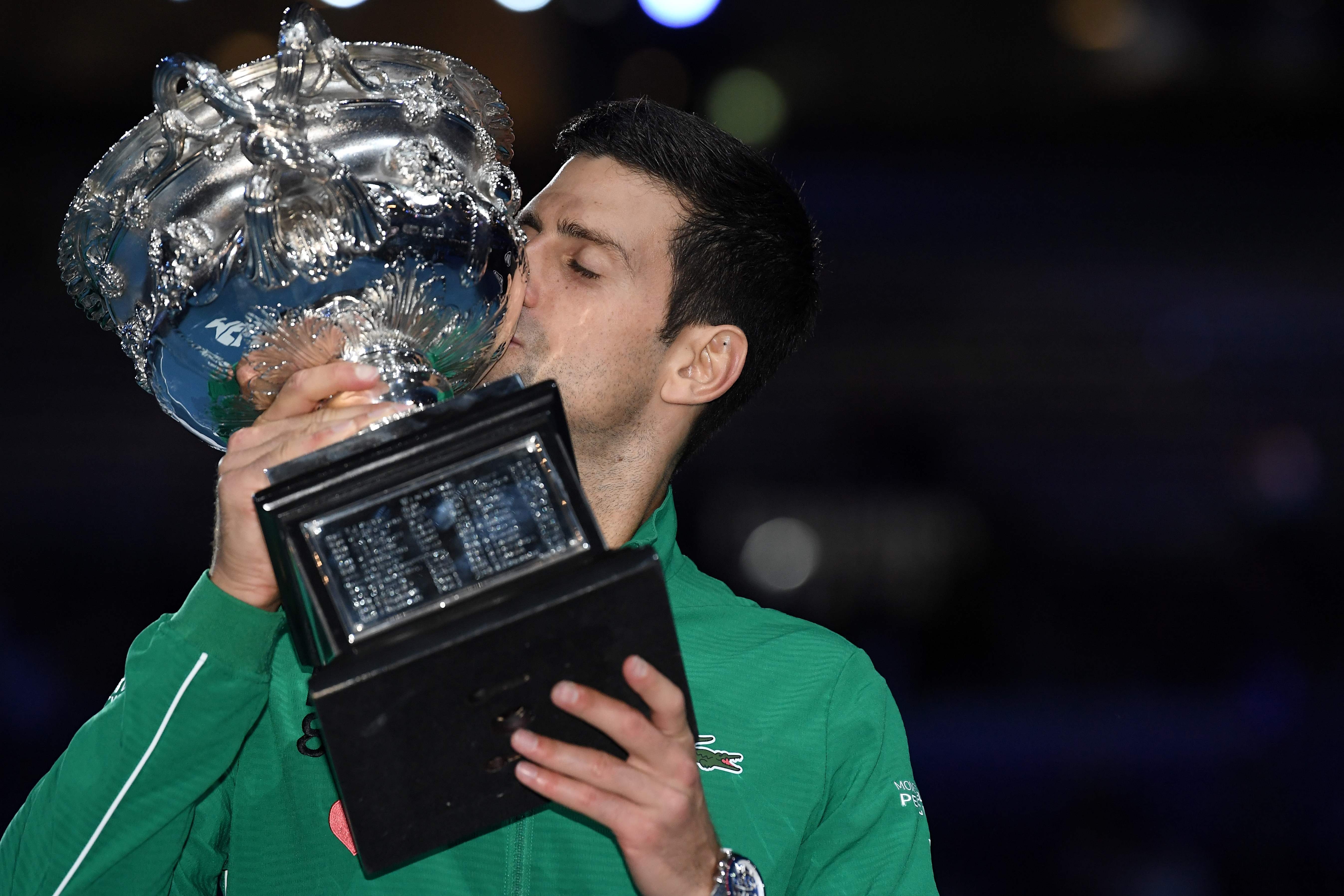 El serbio Novak Djokovic besa el trofeo de la Norman Brookes Challenge Cup después de vencer al dominico Austriaco Dominic Thiem en su último partido de singles masculinos. (Foto Prensa Libre: AFP)