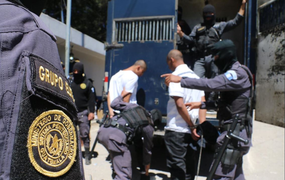 Custodios del Sistema Penitenciario ingresan a un vehículo a reclusos para trasladarlos a Pavoncito. (Foto Prensa Libre: Cortesía SP) 