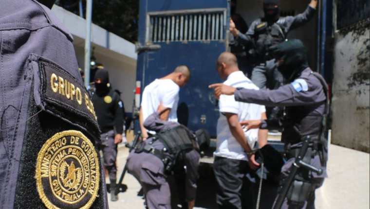 Custodios del Sistema Penitenciario ingresan a un vehículo a reclusos para trasladarlos a Pavoncito. (Foto Prensa Libre: Cortesía SP) 