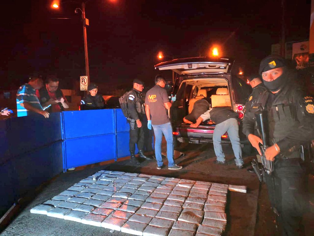 Agentes inspeccionan el vehículo donde han encontrado paquetes con supuesta droga. (Foto Prensa Libre: PNC)