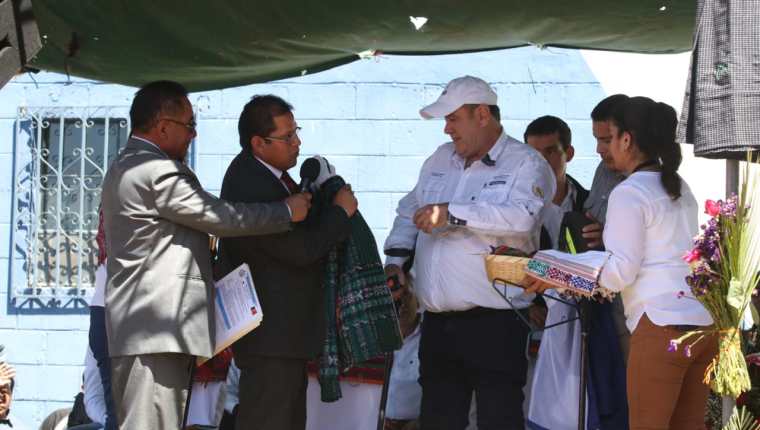 Óscar Chojolán, alcalde de Cantel, entrega una chumpa al presidente Alejandro Giammattei que visitó este municipio. (Foto Prensa Libre: Raúl Juárez) 