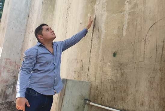 Emilio Mendizábal, presidente del Cocode de segundo nivel de Río Dulce, Lívingston, Izabal, muestra algunas grietas que se encuentran en las bases del puente. (Foto Prensa Libre: Dony Stewart)