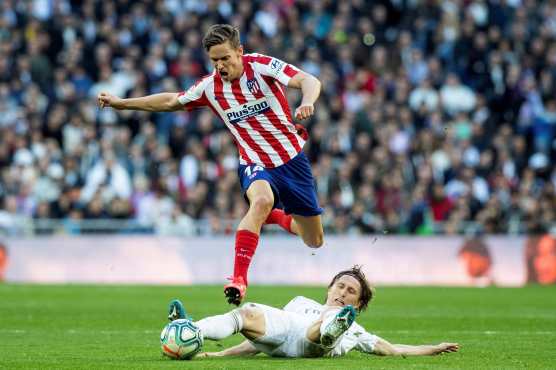 El centrocampista del Atlético de Madrid, Marcos Llorente, disputa el balón con Luka Modric del Real Madrid. (Foto Prensa Libre: EFE)