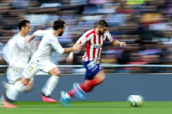 El jugador Yannick Carrasco del Atlético demostró su velocidad al disputar el balón con Daniel Carvajal y Lucas Vázquez del Real Madrid. (Foto Prensa Libre: EFE)
